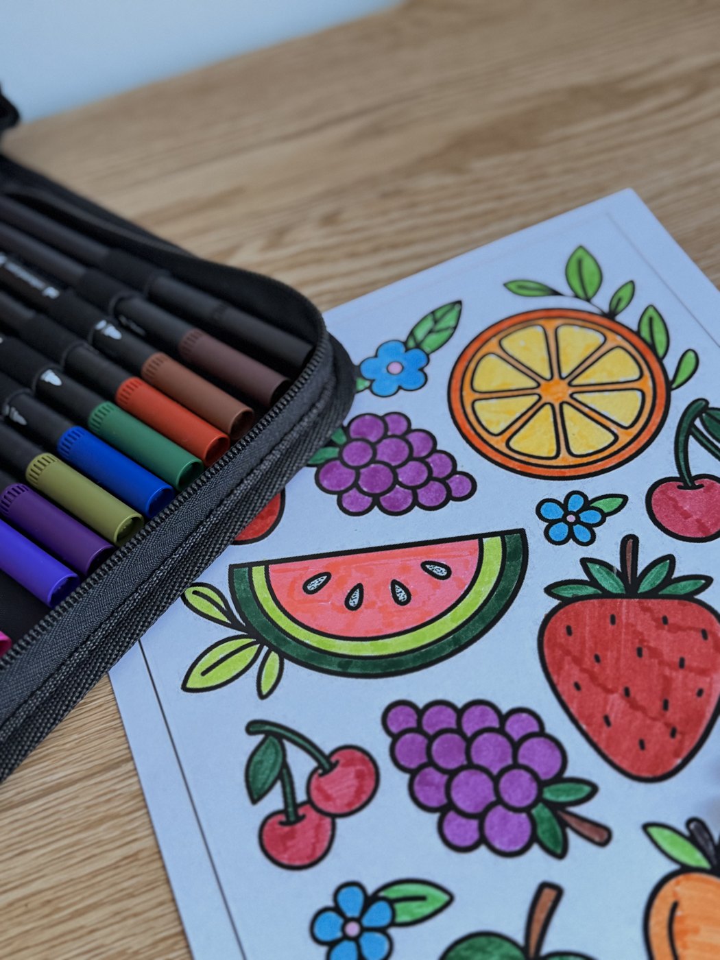 Estuche BRILL abierto junto a una lámina de frutas coloreada